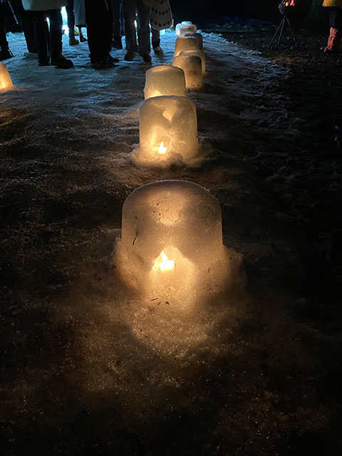 small snow domes with a candle on the ground